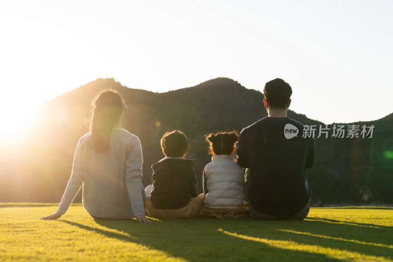 年轻家庭坐在草地上