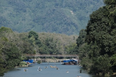 老挝万荣河上多人划艇与山林风景