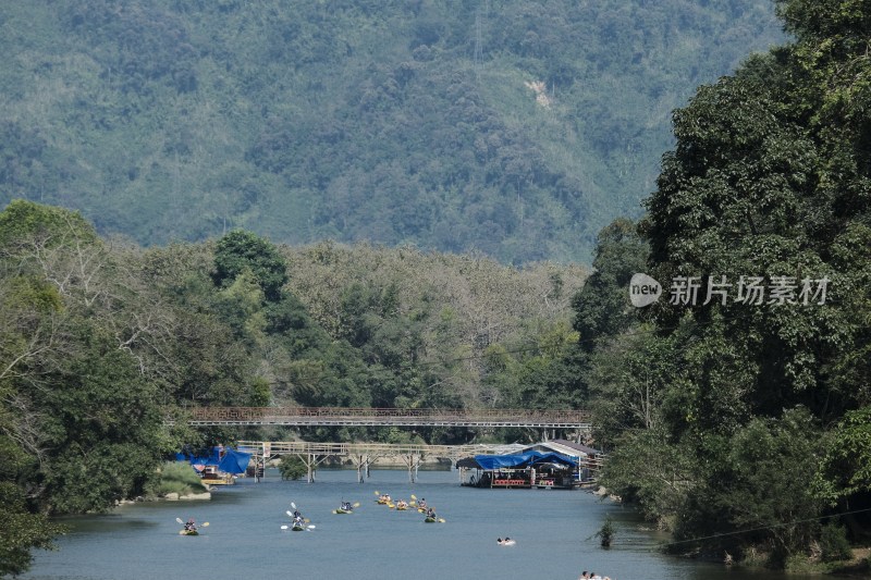 老挝万荣河上多人划艇与山林风景