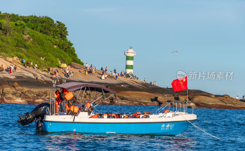 东山岛海边停靠的观光小船与灯塔