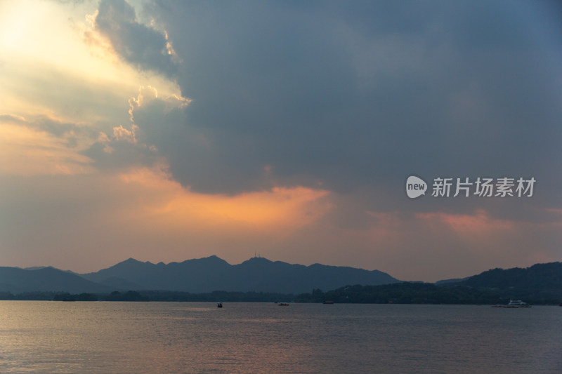 杭州西湖湖面夕阳下的山峦与云彩