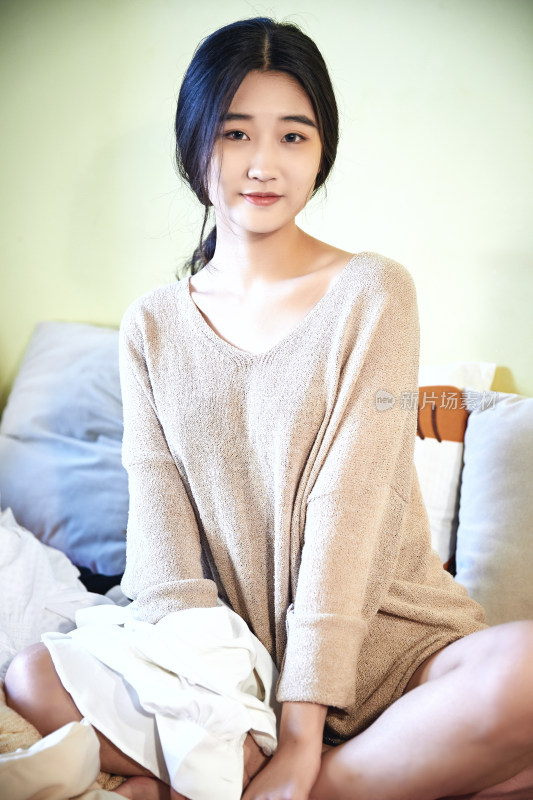 在沙发床上整理行装的年轻亚洲女性