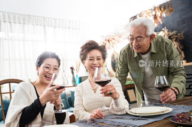 聚会上快乐的老年人们品尝红酒