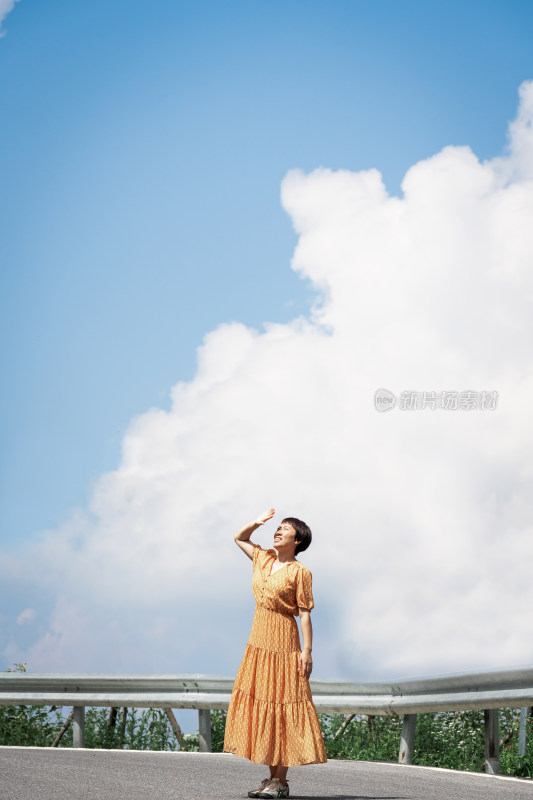 晴朗的夏天午后走在盘山公路上的中国女性