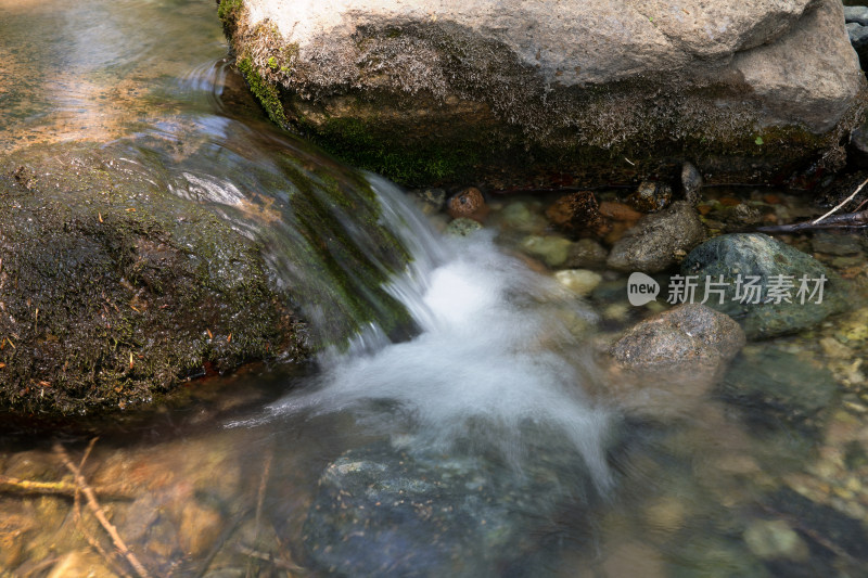 慢门拍摄夏季户外大山里流淌的溪流