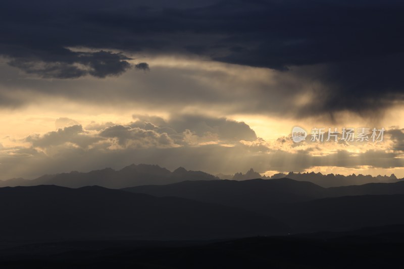 山峰日落时天空映衬的剪影景观