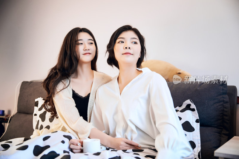 坐在床上玩耍的俩位年轻亚洲美女