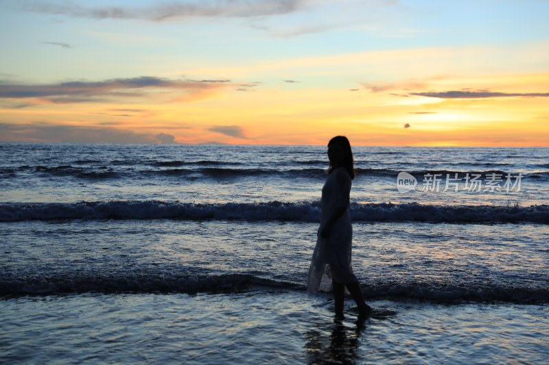 夕阳下海滩上的一个女人