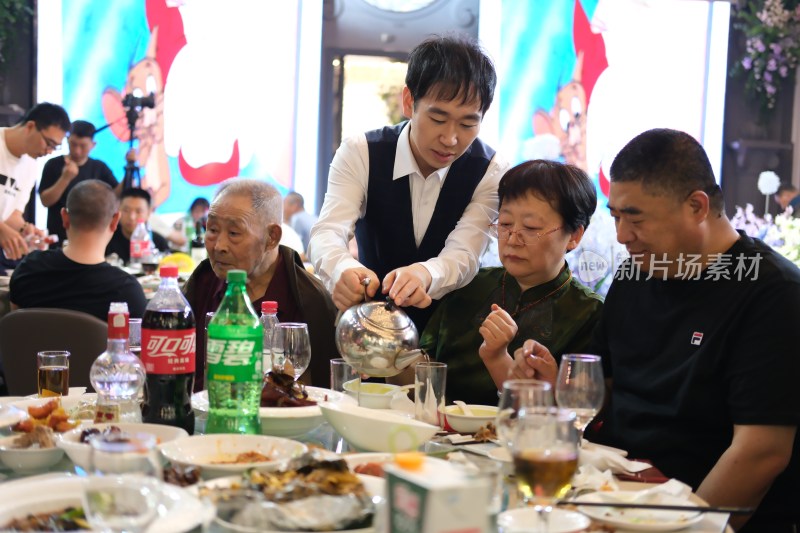 餐厅服务员为顾客倒茶场景