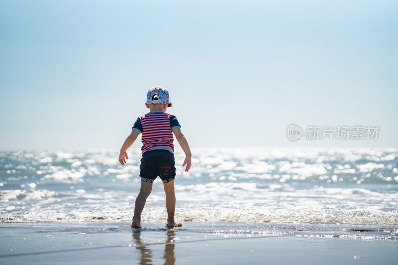 夏天在海边玩沙子的小男孩