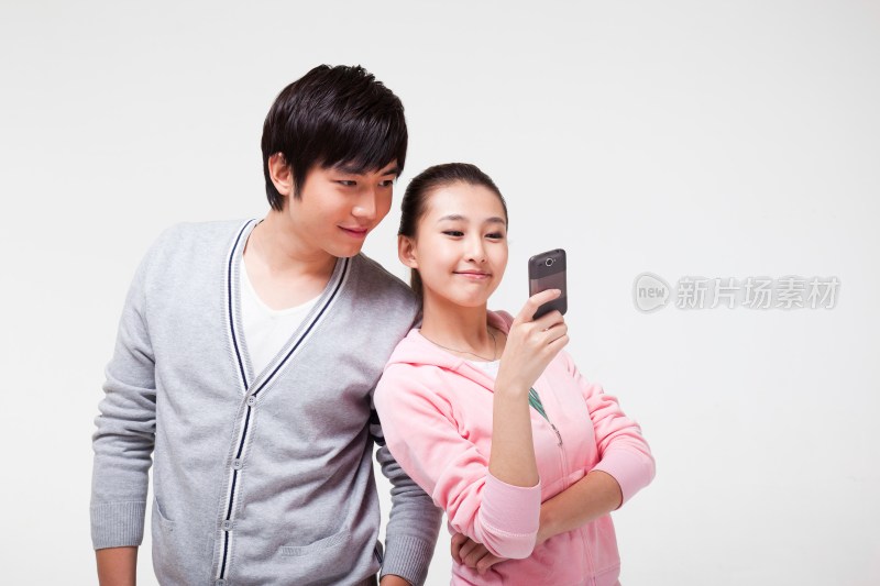 快乐的年轻情侣使用手机