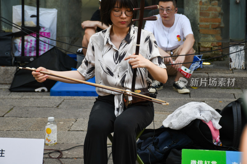 街头女子演奏二胡