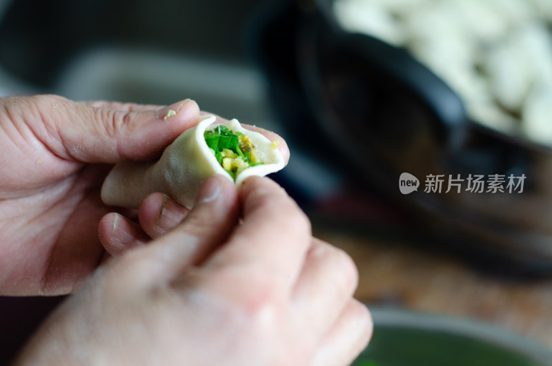 正在包韭菜鸡蛋饺子的女人的手特写