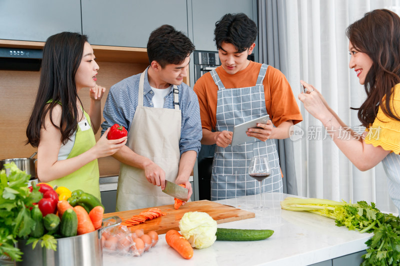 快乐的年轻人在厨房做饭照相