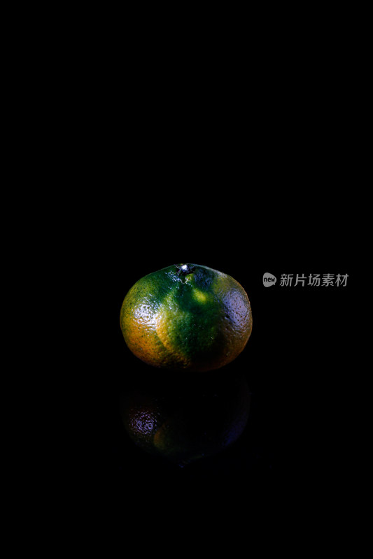黑色背景上的一个新鲜水果橘子