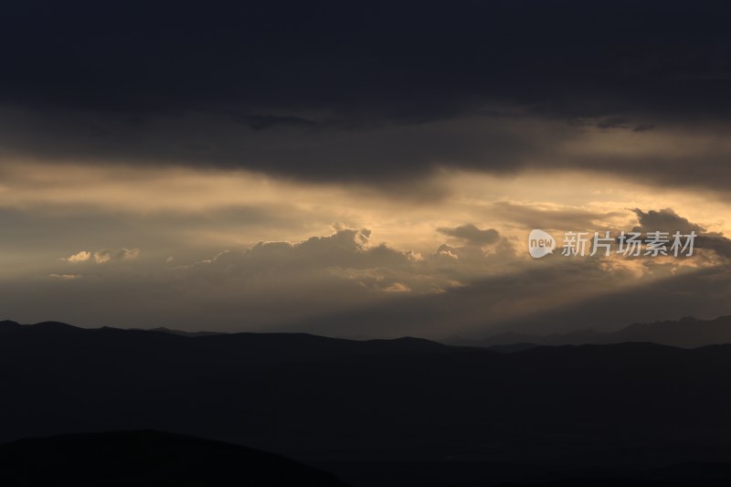 山峰日落时天空映衬的剪影景观