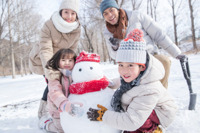 欢乐家庭在雪地里堆雪人