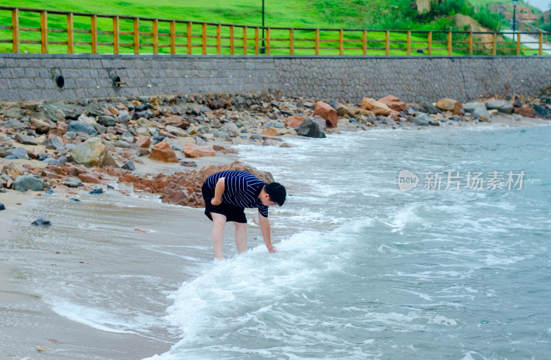 青岛小麦岛，海边一个戏水的男人