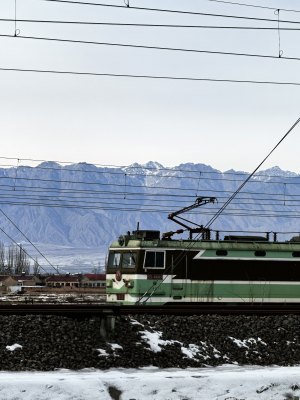 雪山下行驶的绿皮火车