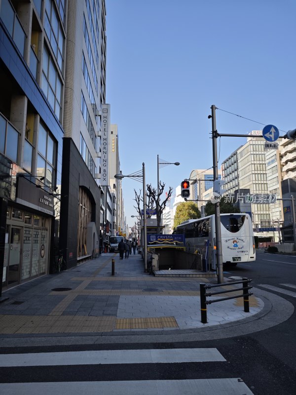 大阪城市街道景象，人行道上行人往来