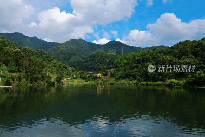 蓝天白云下的山与湖泊背景