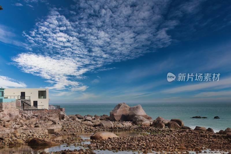 海边石滩与白色建筑风景