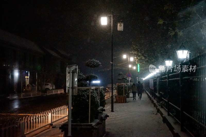 夜晚下雪行人街道