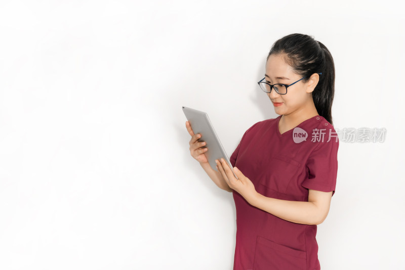 站在白色背景前使用平板电脑的中国女性