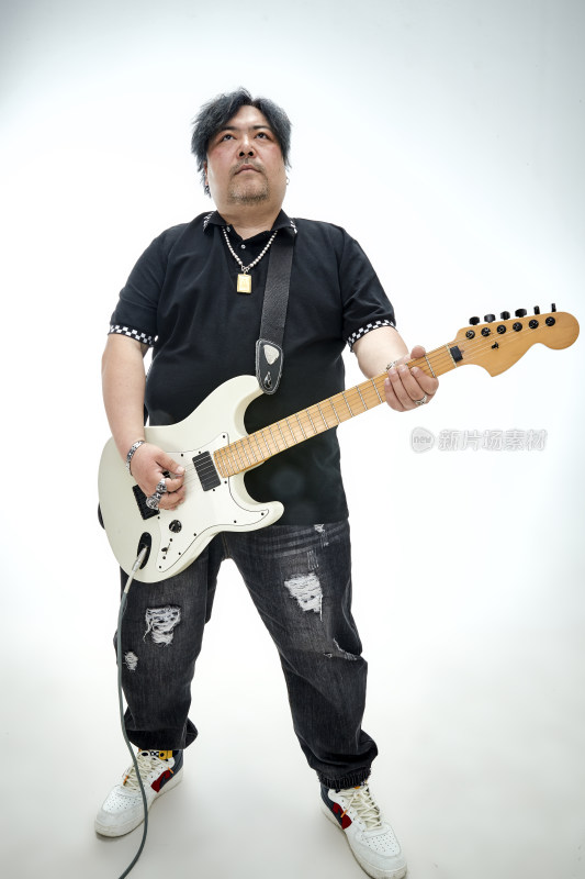 手持电吉他展示演奏的亚洲男性摇滚乐手人像