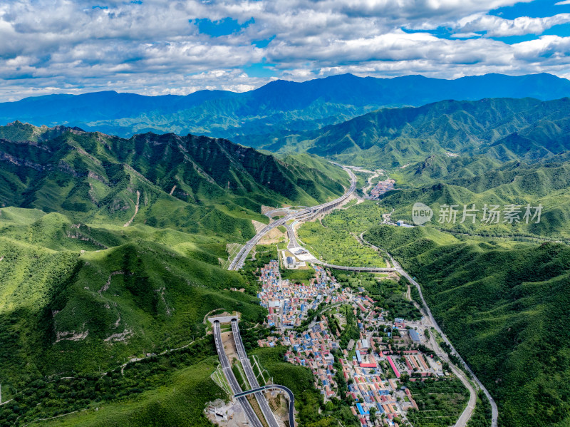 航拍京蔚高速公路蜿蜒穿过绿意盎然的山谷