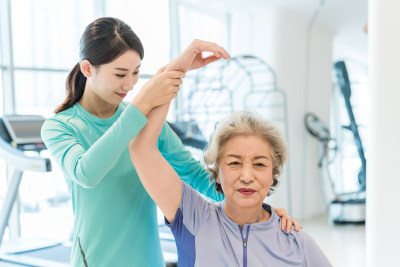 老年女子在私教的指导下健身