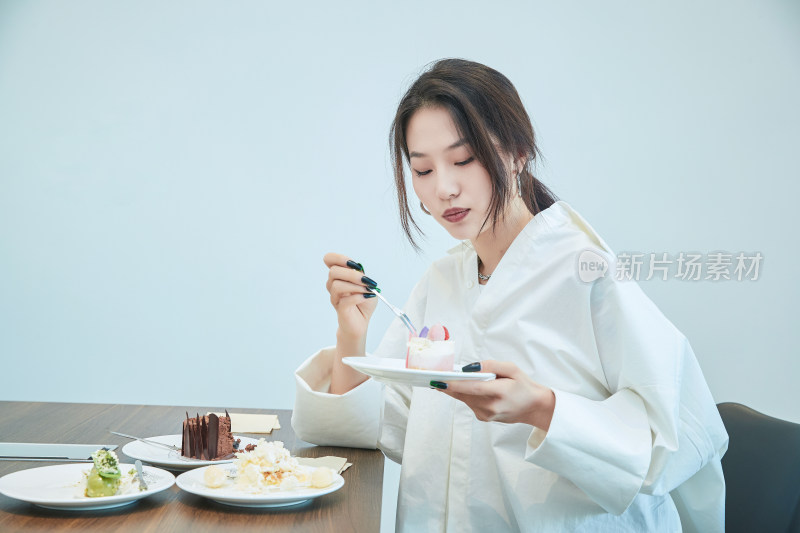 在烘焙店吃蛋糕喝饮料的可爱亚洲少女