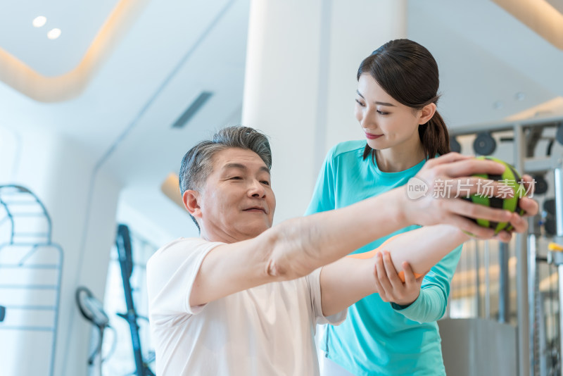 老年男子在私教的指导下健身