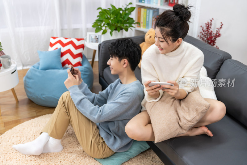 年轻情侣在家玩手机