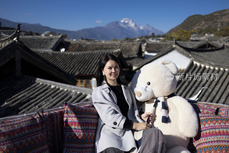 在丽江古城旅行的美女 背后是玉龙雪山