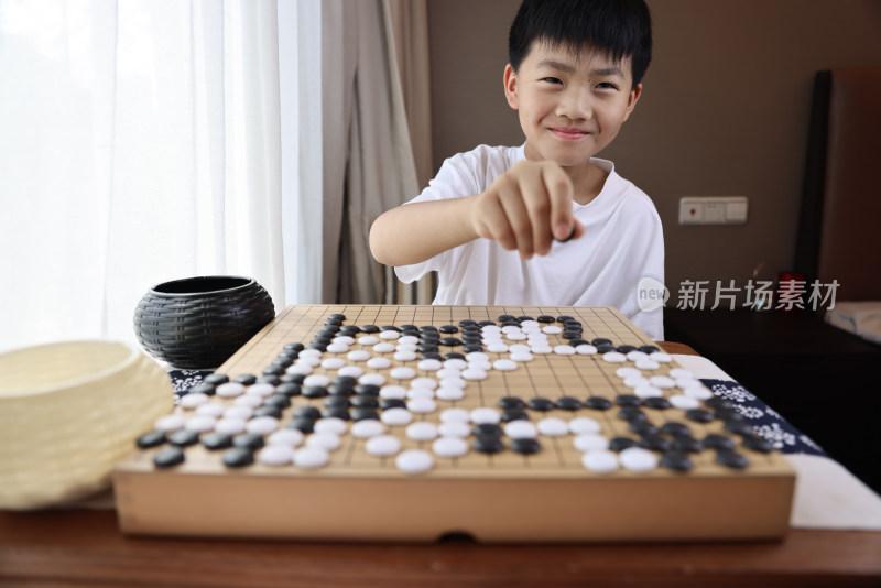 可爱的男孩在窗边下围棋