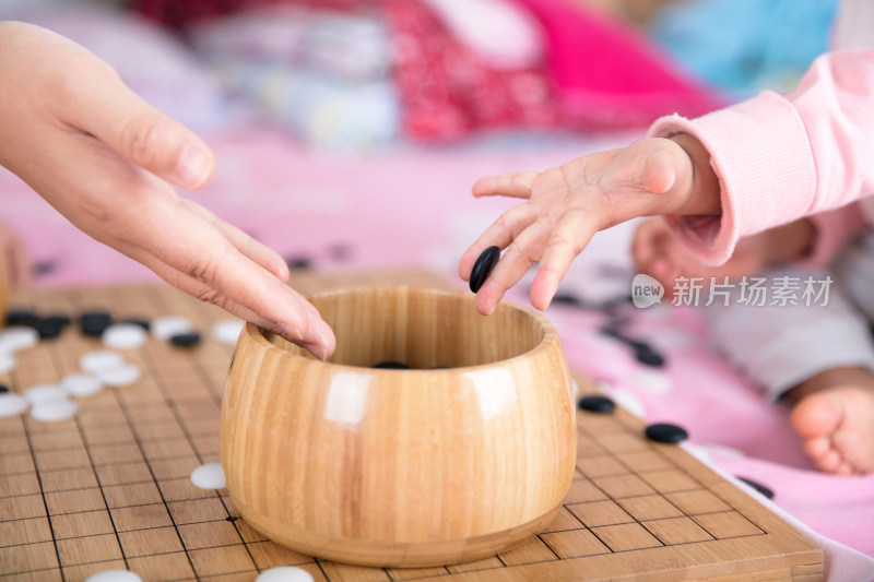 一只小手正把棋子放入棋盒中