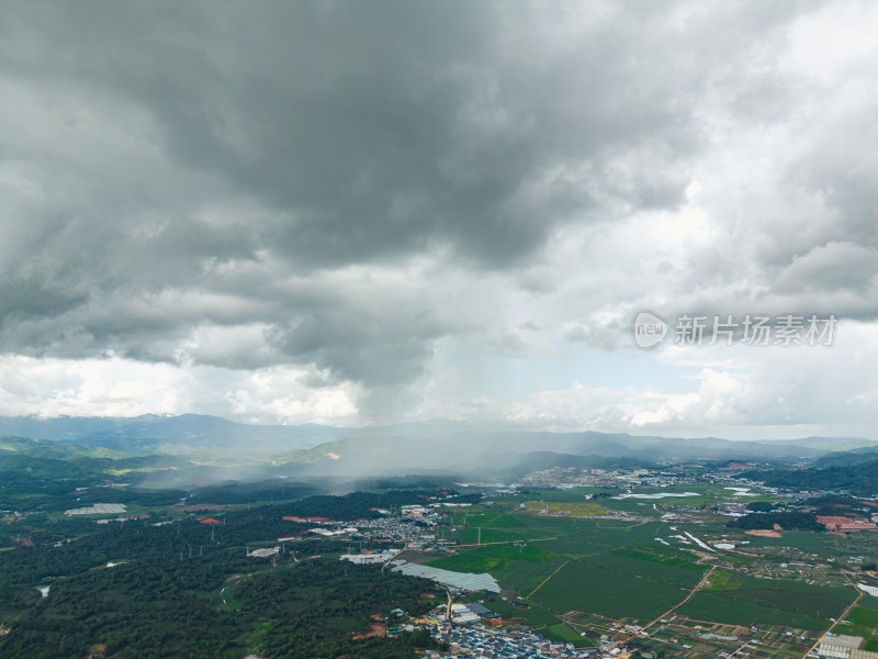 航拍乌云暴雨下的勐海县田园风光