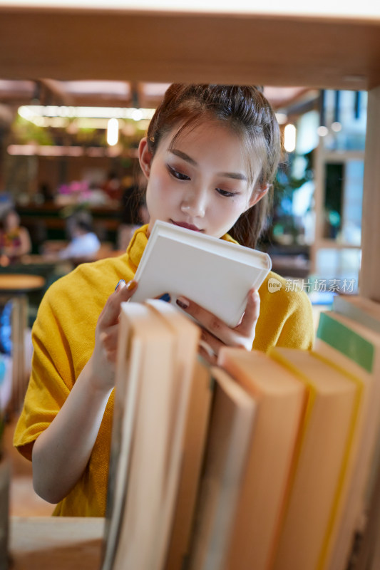 在图书咖啡馆阅读书籍的少女