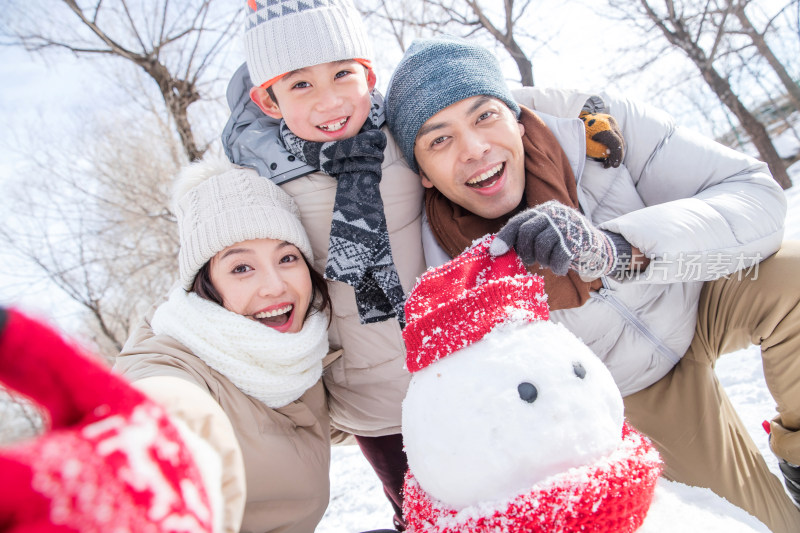 一家三口在雪地里堆雪人