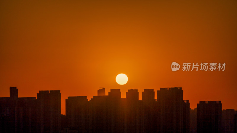 清晨城市高层住宅与日出太阳