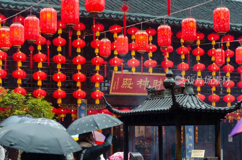 雨中的上海城隍庙的财神殿前信众众多