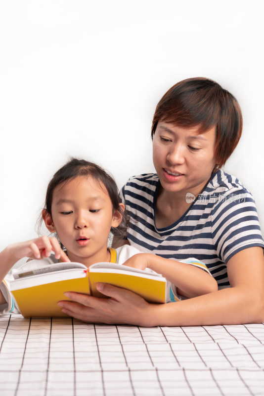 白色背景前年轻的中国籍母女在读书