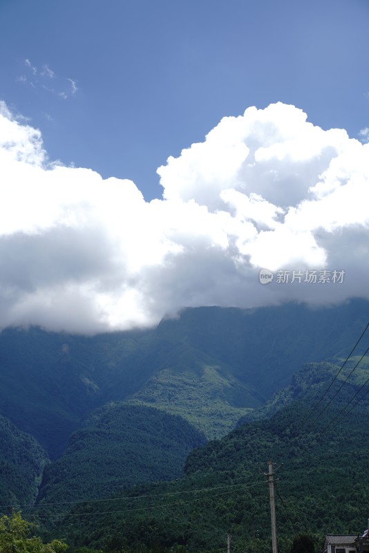 壮阔山脉上空白云朵朵的自然美景