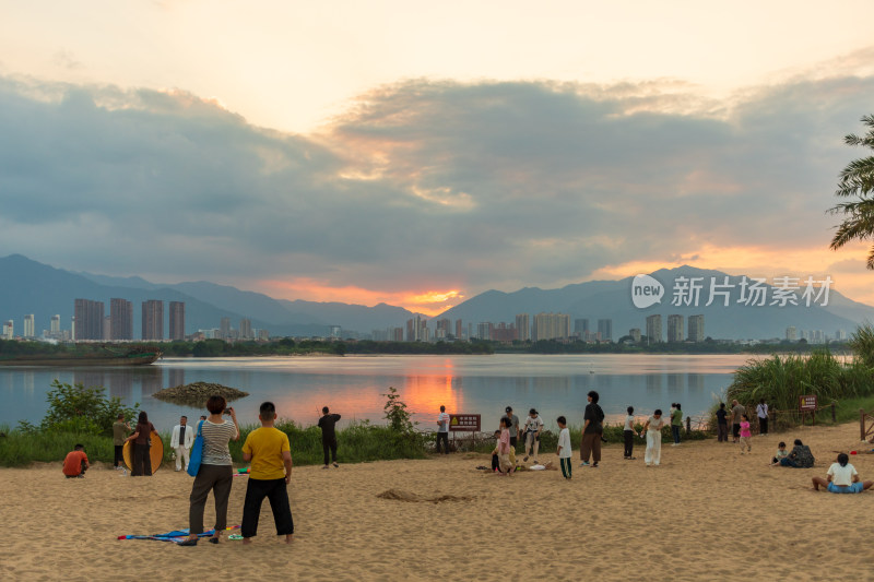 湖边沙滩人群赏日落场景