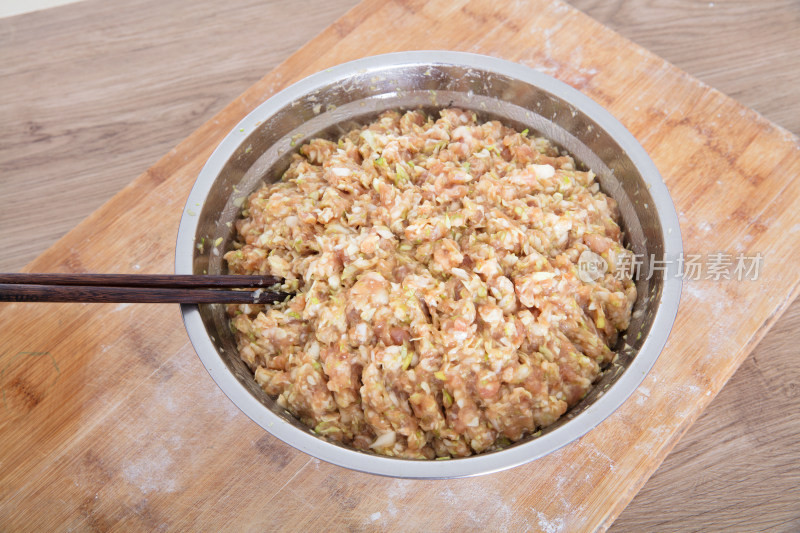 砧板上放着一盆剁好的猪肉大葱饺子陷