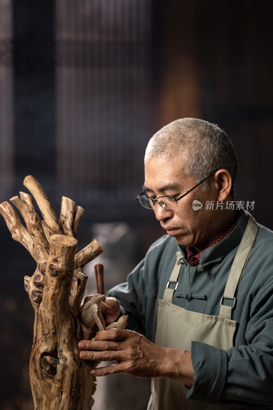 在树根上认真雕刻的工匠师