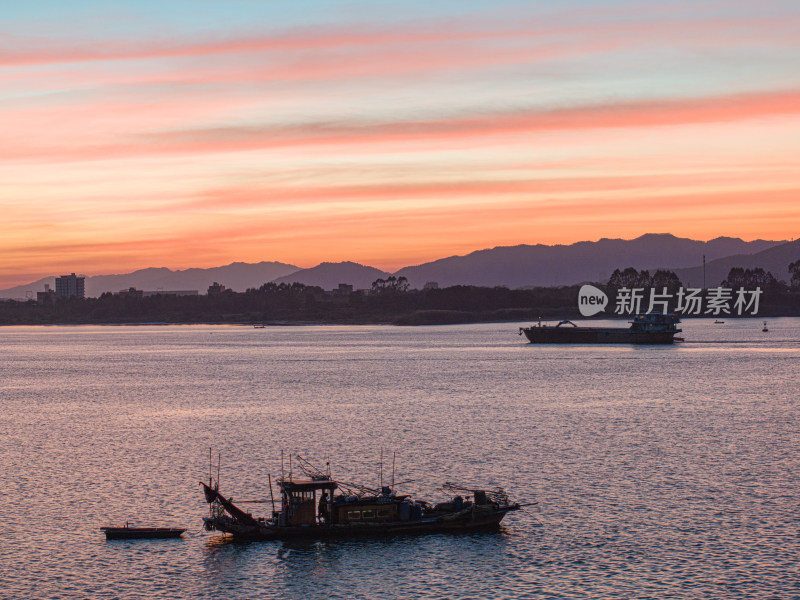 江面上的渔船与绚烂天空构成的美丽景象