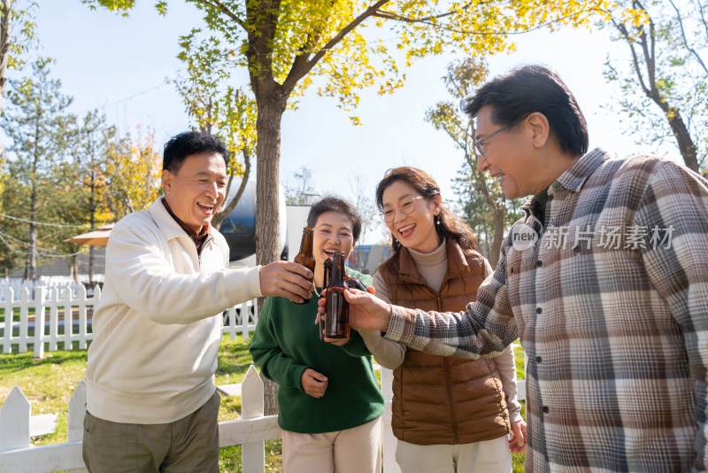 一群中老年人站在房车露营地喝啤酒