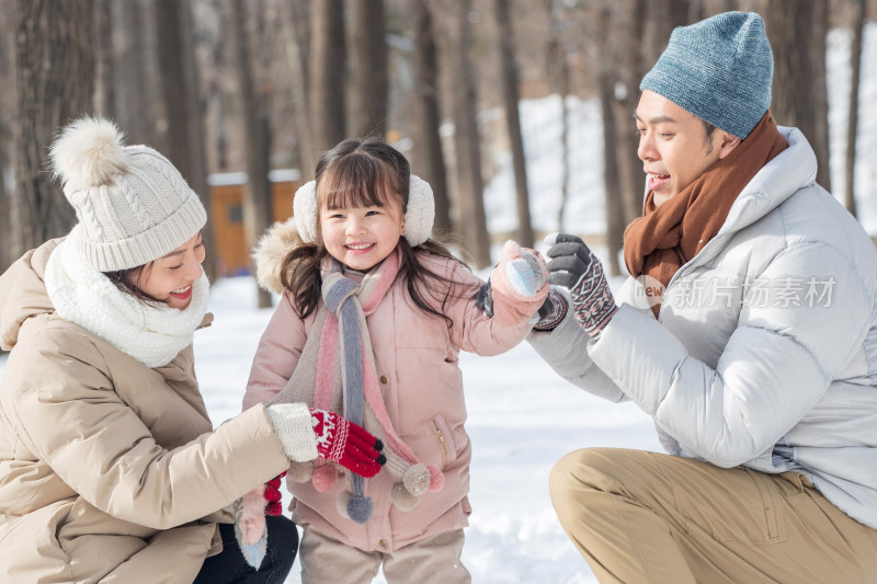 一家三口在雪地里玩耍